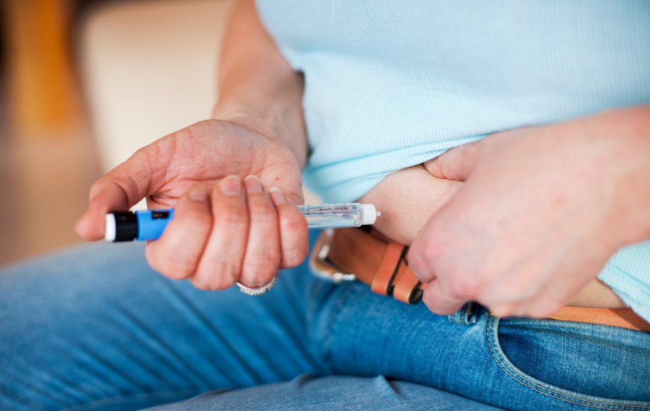 Eine Frau behandelt ihren Diabetes, indem sie sich mit einem Insulinpen Insulin spritzt.